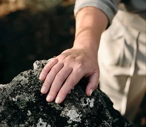 Detail of hand resting on a rock