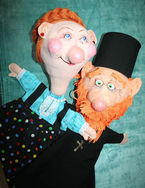A women and a priest puppets