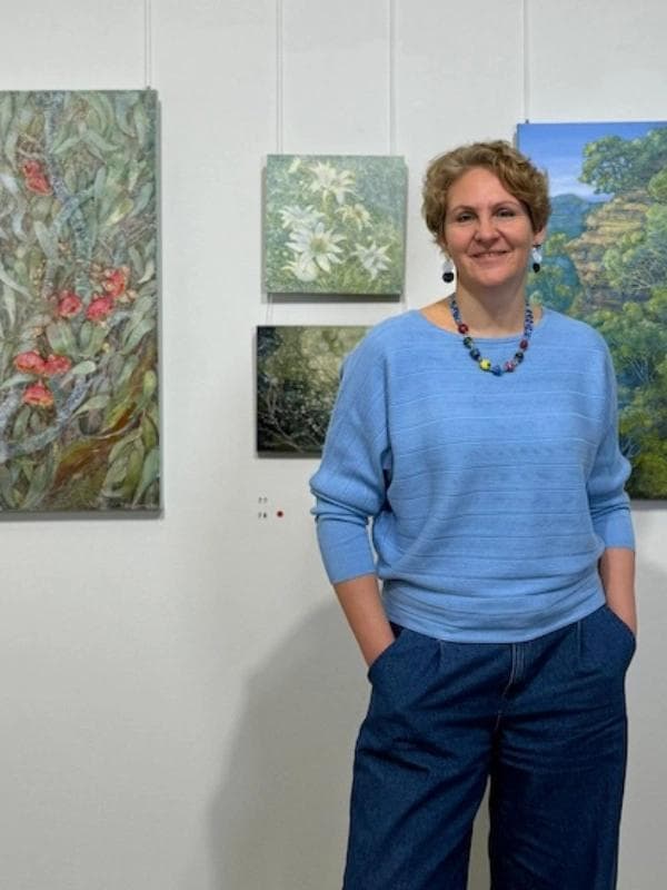 Contemporary artist Tetiana Koldunenko at her art exhibition in Sydney, showcasing realistic Australian landscape paintings.
