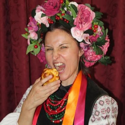 A girl in traditional Ukrainian costume eating a bun