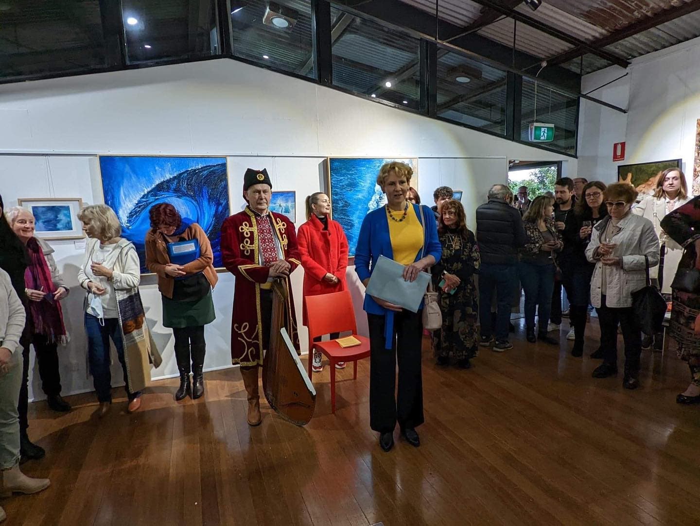 Tetiana Koldunenko artist is talking in front of the paintings at the gallery