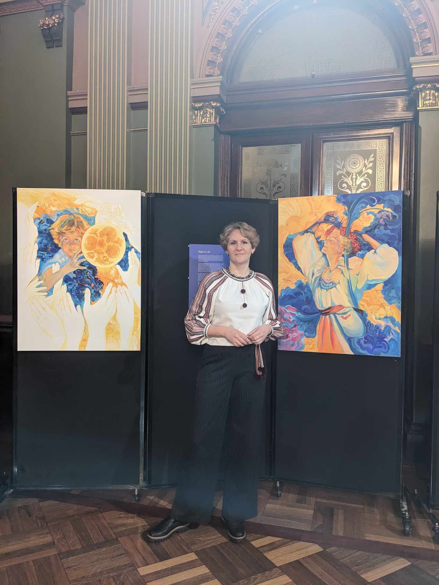 Artist Tetiana Koldunenko in front of her artworks